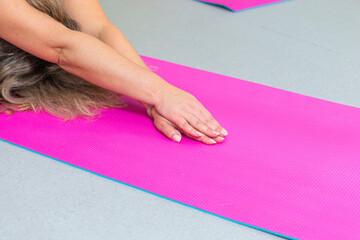 hands of Mature People Practicing Stretching Yoga Exercice on Mats With Body Flex Bending in Room...