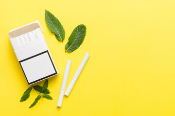 Pack of menthol cigarettes and fresh mint on colored table, Menthol cigarettes top view flat lay