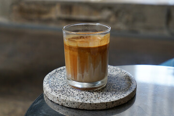 Close up glass of Dirty Latte coffee on ceramic tray