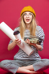 Laughing Winsome Caucasian Young Blond Girl In Glasses Posing With White Advertising Copy Space Rolling Paper List With Disposable Cup And Sushi Box Over Burgundy Background.
