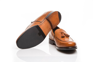 Mens Footwear Concepts. Closeup View of Pair of Traditional Formal Stylish Light Brown Polished Calf Leather Tassel Loafer Shoes On White Surface