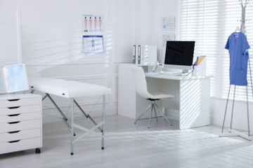 Doctor's workplace with modern computer and examination table in medical office