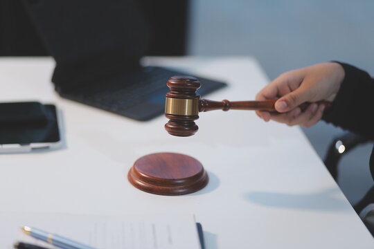 Judge gavel with Justice lawyers having team meeting at law firm background. Concepts of Law and Legal services. - Powered by Adobe
