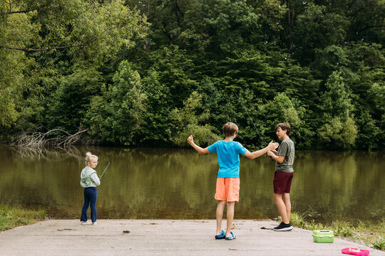 Kids fishing on boat ramp and telling fish tales