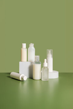 White cosmetic bottles isolated on green background. Skin care.