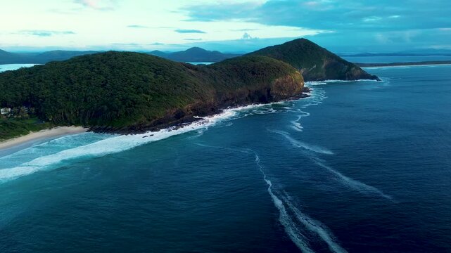 Drone aerial landscape of rugged bushland trees and mountain range in Booti Booti National Park headland coastline with ocean reef and sandy bay Elizabeth Beach Pacific Palms Forster travel holidays