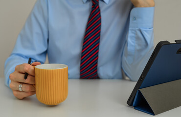Businessman with a cup of coffee uses the internet