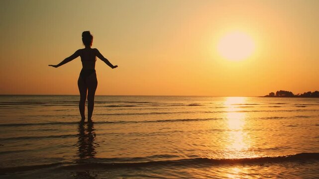 Woman practicing yoga pose by the sea at sunset, silhouette symbolizing mindfulness, balance, and inner peace in a serene natural setting.