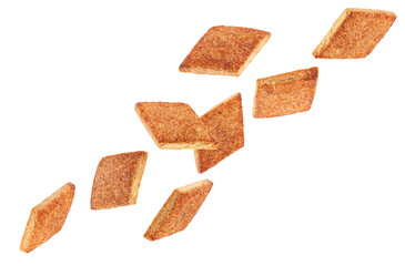 Diamond shaped cookies glazed with cinnamon and sugar fly through space forming an unusual figure. Isolated on white