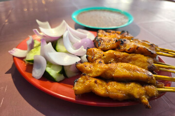 Grilled Chicken Satay Skewers with Cucumber, Onion, and Peanut Sauce
