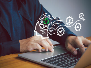 A person using laptop with digital icons representing recycling, sustainability, and innovation, symbolizing eco friendly technology and green business concepts