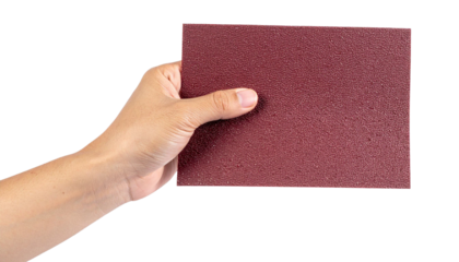 Worker holding a sheet of red sandpaper with transparent background, ready for sanding and polishing