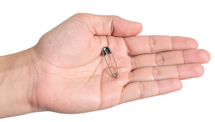 Hand revealing closed safety pin on transparent surface, highlighting metallic sheen and precise craftsmanship