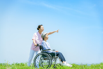 車椅子のシニアと介護士