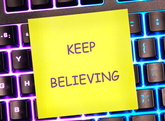 Business concept. Copy space. Concept Words KEEP BELIEVING written on a bright yellow sticker on a...