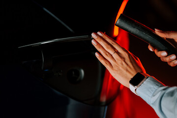 Woman charging electric car in underground parking lot during evening hours