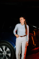 Woman charges electric car in underground parking lot during evening hours