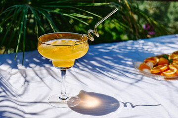 Summer refreshing orange soda drink on the table in the garden. Iced lemonade with orange slices.