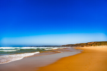 Empty Bordeira beach in Portugal. Beautiful Algarve coastline. View at sandy beach and cliffs
