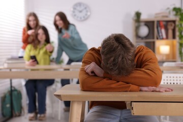 Teenage boy suffering from bullying at school, selective focus