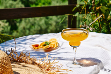 Summer refreshing orange soda drink on the table in the garden. Iced lemonade with orange slices.