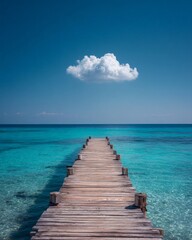 Obraz premium Wooden Pier Extends Into Turquoise Ocean Under Blue Sky With Cloud