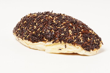 Milk bread with a soft white interior, topped generously with chocolate sprinkles and a touch of white topping. Photographed against a clean white background.