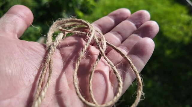 scourge. Texture of Natural Jute Twine. High-resolution texture of natural jute twine, showing its rough fibers and organic weave. scourge in hand. Jute burlap rustic twine string rope cord.