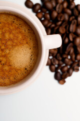 Close-up of a freshly brewed cup of espresso with coffee beans, offering a rich aroma and flavor