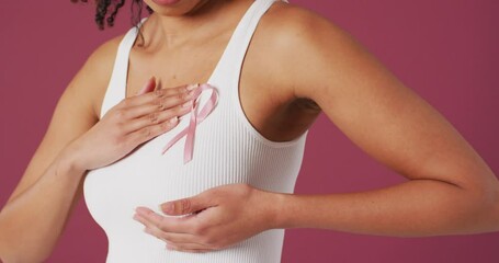 Video of woman touching her pink breast cancer ribbon - Powered by Adobe