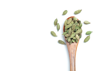 Green cardamom seeds in a wooden spoon on white background, Top view