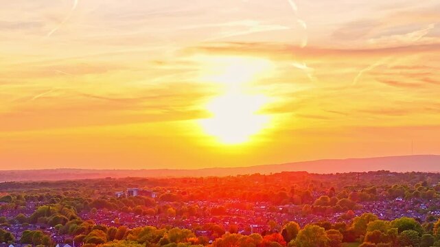 Aerial: fire sky sunset over Heaton Park in Prestwich, Manchester, England, crane down drone shot