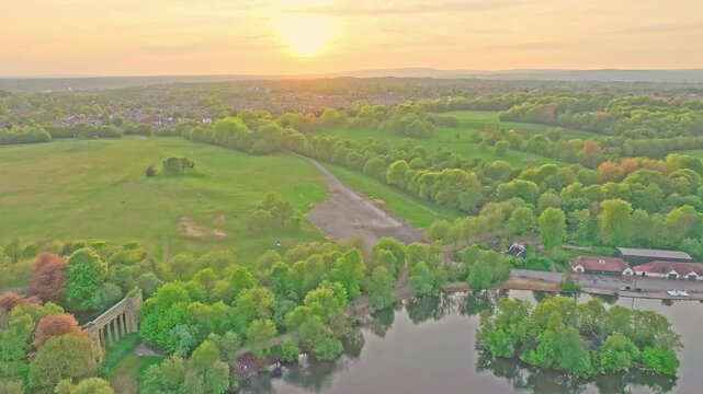 Aerial: Heaton Park at sunset with lake during the day in Prestwich, Manchester, England, static drone shot