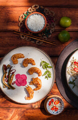 Crispy fried shrimp served with smashed cucumber salad and marinated daikon. Bright and flavorful Vietnamese dish captured in flat lay style