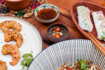 Authentic Vietnamese cuisine including pho bo, spring rolls with shrimp and noodles, fried shrimp, chicken noodles, rice, and pickled vegetables. Flat lays and styled food shots
