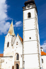 Fototapeta premium Church of the Nativity of the Virgin Mary showing its imposing white bell tower in Pisek, Czechia