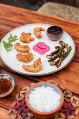 Crispy fried shrimp served with smashed cucumber salad and marinated daikon. Bright and flavorful Vietnamese dish captured in flat lay style
