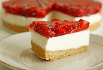 Slice of Classic Cheesecake with a pieces of strawberry strawberry and jelly. Homemade dessert decorated with strawberries. Empty space for text