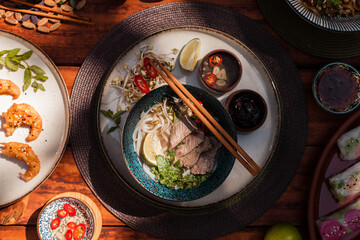 Authentic Vietnamese cuisine including pho bo, spring rolls with shrimp and noodles, fried shrimp, chicken noodles, rice, and pickled vegetables. Flat lays and styled food shots