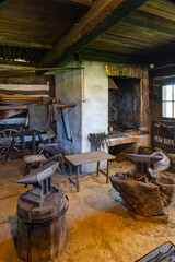 Traditional blacksmith workshop interior showing anvils, tools, and forge in Kourim, Czechia