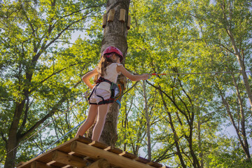 Rope climbing adventure in a lush forest with a young girl