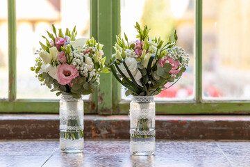 Two wedding bouquets resting on windowsill, waiting for the bride and bridesmaid