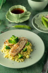Delicious grilled white fish fillet seasoned with sesame seeds, served on a bed of couscous with broccoli