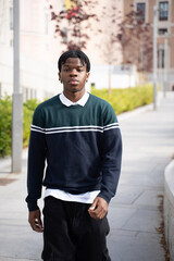 Confident young university student walking on a campus sidewalk, enjoying the fresh air and academic atmosphere