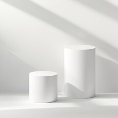 Two white cylindrical podiums in a sunlit space