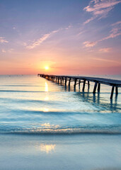 Endless Wooden Pier with wooden planks Stretching Over the Mediterranean Sea at a Vibrant Summer Sunrise