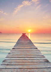 beautiful Wooden Pier Leading Over the Crystal Mediterranean Under a Radiant Summer Sunrise