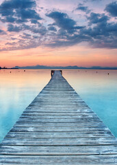 Serene Wooden Pier Vanishing Into the Golden Embrace of a Mediterranean Summer Sunrise