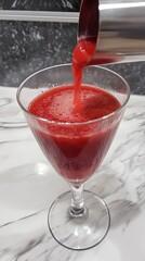 raspberry bellini in flute with fruit puree.