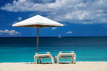 Parasol and loungers on the sandy beach in the Caribbean